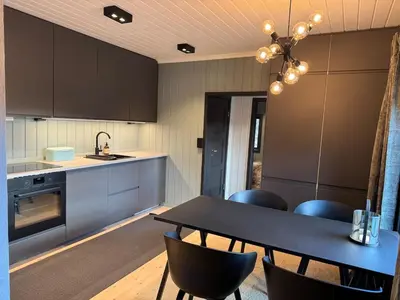 a kitchen with a table and chairs and a sink at Smart and beautiful micro house - Great base for mountain adventures in Hedalen