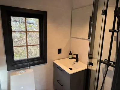 a bathroom with a sink and a window and a toilet at Smart and beautiful micro house - Great base for mountain adventures in Hedalen