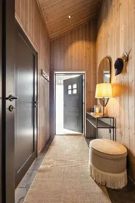 a hallway with a door and a stool and a table at Premium Cabin By Kvitfjell Ski Slopes in Ringebu
