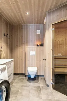 a bathroom with a toilet and a wooden wall at Premium Cabin By Kvitfjell Ski Slopes in Ringebu