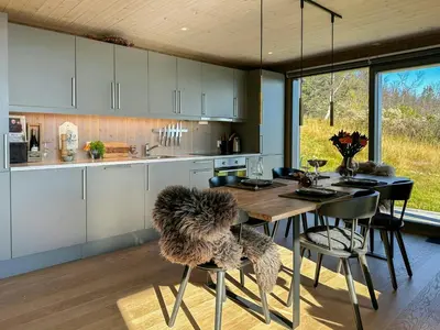 a kitchen with a wooden table and some chairs at Architect Designed Cabin With Panoramic Views in Ål