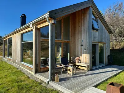 a house with large glass doors on a deck at Architect Designed Cabin With Panoramic Views in Ål