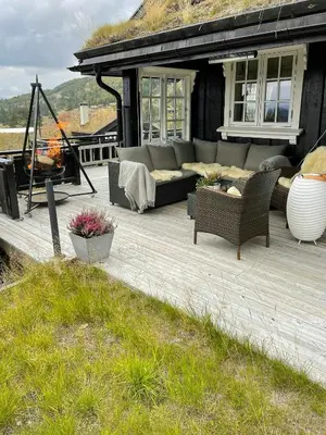 a patio with a couch and chairs and a fireplace at Cabin With Ski Inski Out In Rauland in Rauland