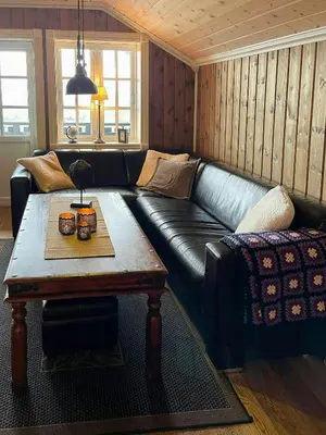 a living room with a black leather couch and a coffee table at Cabin With Ski Inski Out In Rauland in Rauland