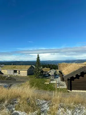 a barn with a grass roof on a hill at Architect-Designed Mountain Cabin At Mosetertoppen in Øyer