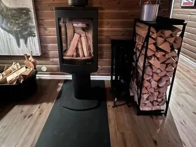 a room with a fireplace and a wooden wall at Mountain Cabin With Views Over Nesfjellet in Nesbyen