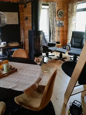 a living room with a fireplace and a table and chairs at Charming Small Cabin At The Top Of Blefjell in Flesberg