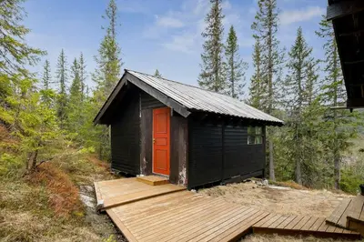 a small cabin with a red door on a wooden deck at Close To Nature In Ål Cabin At Haglebu in Eggedal