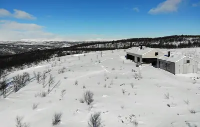 an aerial view of a snow covered field with a building at Cabin Overlooking Hallingskarvet National Park in Geilo