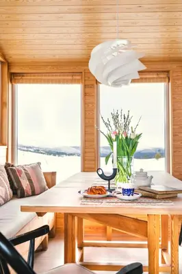 a dining room with a table with flowers on it at Architect Drawn Holiday Home Near Rondane Park in Høvringen
