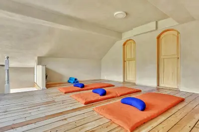 three beds in a room with orange cushions at Peaceful Smallholding With Yoga Studio in Traut