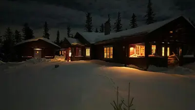 a house covered in snow at night with lights at Cabin With Sauna In Vegglifjell in Veggli