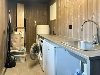 a kitchen with a sink and a washing machine at Stylish Cabin In Scenic Stryn in Stryn