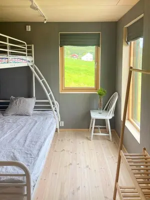 a bedroom with a bunk bed and a window at Architect-Designed Cabin With Beach Nearby in Lensvik