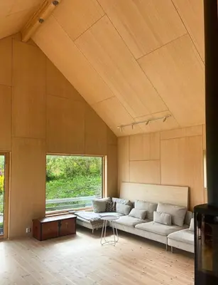 a large living room with a couch and a table at Architect-Designed Cabin With Beach Nearby in Lensvik
