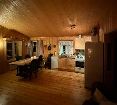a kitchen with a table and a refrigerator at Family-Friendly Cabin In Nordseter Near Ski Trails in Lillehammer