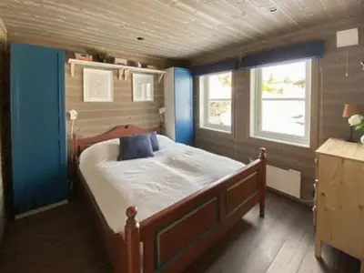 a bedroom with a large bed with blue walls at Traditional Cabin With Views Of Hardangervidda in Uvdal