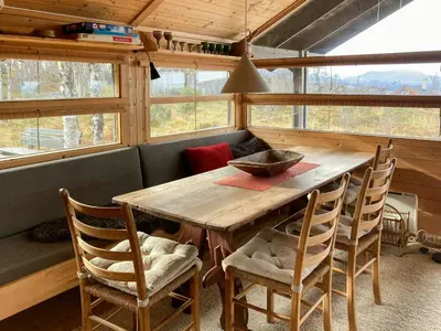 a dining room with a wooden table and chairs at Ålhytte Near Vasetvannet in Ron