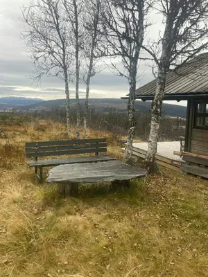 a wooden bench sitting on top of a field at Ålhytte Near Vasetvannet in Ron