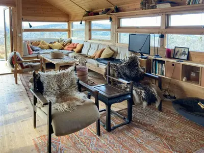 a living room with a couch and a tv at Ålhytte Near Vasetvannet in Ron