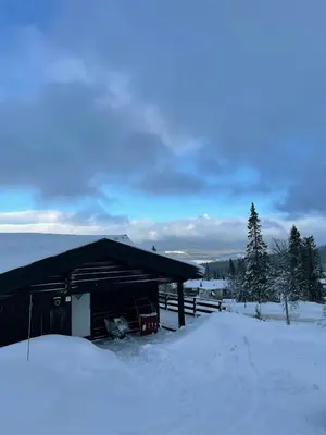 a building covered in snow with trees in the background at Log Cabin With Views Over Trysil Mountain in Trysil