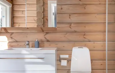 a bathroom with a white sink and wooden walls at Amazing Home In Lesjaskog With Wifi in Bjorli