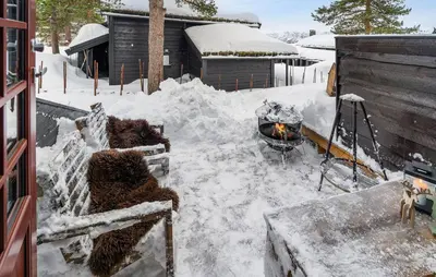 a snow covered yard with a grill and a fire at Amazing Apartment In Hovden I Setesdal in Hovden