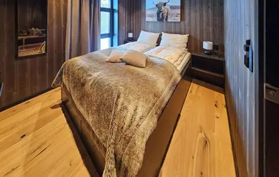 a bedroom with a bed with a blanket on it at Awesome Home In Rjukan With Sauna in Rjukan