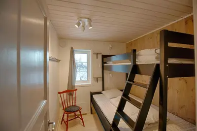 a bedroom with two bunk beds and a chair at New 4Bedroom Cabin With Sauna, Terrace & Fireplace in Beitostøl