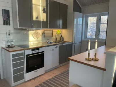 a kitchen with gray cabinets and white appliances at New 4Bedroom Cabin With Sauna, Terrace & Fireplace in Beitostøl