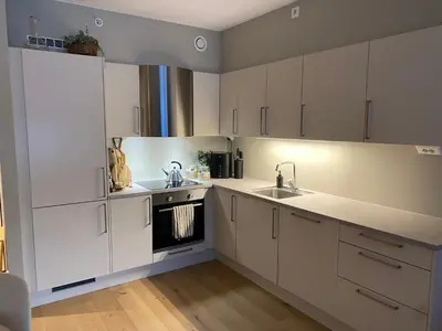 a kitchen with white cabinets and a sink at Modern, big and central apartment in Trondheim in Trondheim
