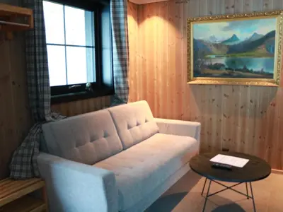 a living room with a white couch and a table at Trysil turistesenter liten leilighet in Trysil