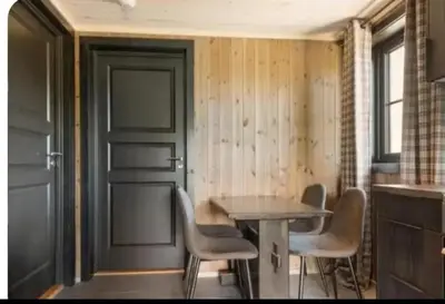 a dining room with a table and chairs and a door at Trysil turistesenter liten leilighet in Trysil