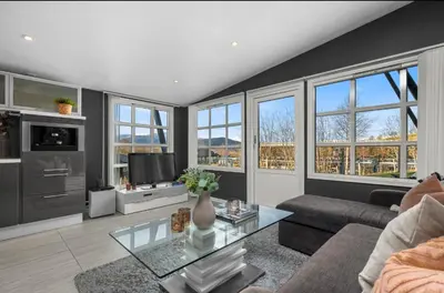 a living room with a couch and a tv at Ski inn Ski Out Best holiday Apartments i Oppdal in Oppdal