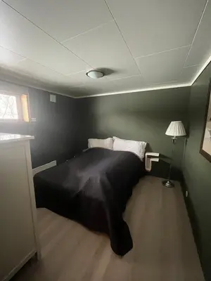 a bedroom with a bed with a black blanket at Sokkelleilighet i enebolig in Sula