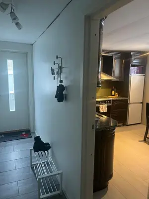 a kitchen with a white wall with a camera on it at Sokkelleilighet i enebolig in Sula