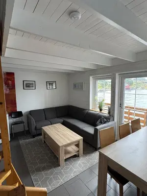 a living room with a couch and a table at Cozy Oceanfront Escape in Nautnes