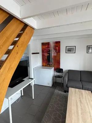 a living room with a couch and a television at Cozy Oceanfront Escape in Nautnes