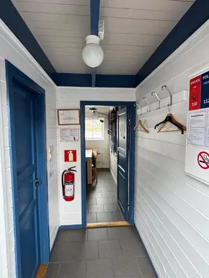 a hallway of a house with a blue door at Cozy Oceanfront Escape in Nautnes