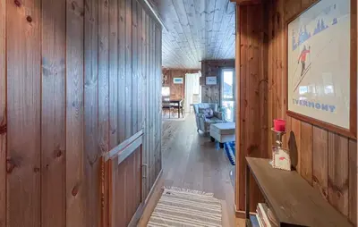 a hallway with wood paneled walls and a living room at Cozy Home In Sjusjøen With Sauna in Sjusjøen