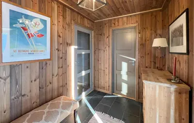 a room with wooden walls and a hallway with a door at Cozy Home In Sjusjøen With Sauna in Sjusjøen