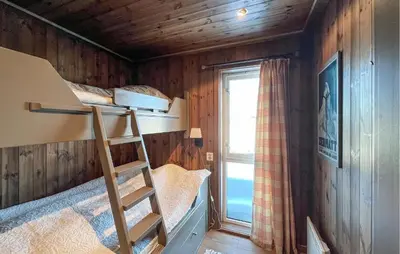 a room with a bunk bed with a ladder and a window at Cozy Home In Sjusjøen With Sauna in Sjusjøen