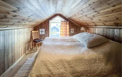 a bedroom with a bed in a room with a window at Cozy Home In Sjusjøen With Sauna in Sjusjøen