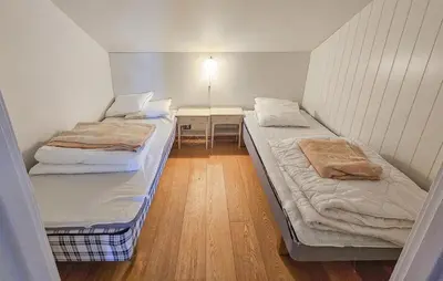 two beds in a small room with a desk at 5 Bedroom Cozy Apartment In Ustaoset in Ustaoset