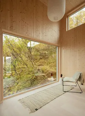 a room with a chair and a large window at Architect Drawn Cabin With Sea View At Stokkøy in Hosen