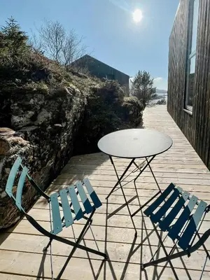 two chairs and a table and a table and chairs at Architect Drawn Cabin With Sea View At Stokkøy in Hosen