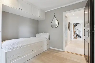 a white bedroom with a bed and a hallway at Ringåsen in Berg