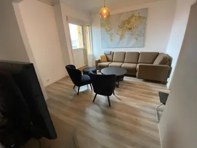 a living room with a couch and a table and chairs at Central appartment with a nice view in Bergen