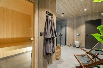 a bathroom with a walk in shower and wooden walls at Family Cabin At The Foot Of Gaustatoppen in Rjukan