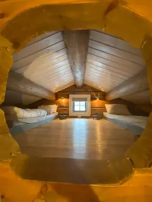 an attic room with two beds and a window at Charming Log Cabin In Jøldalen in Rennebu